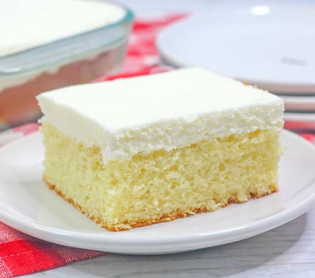 close up of vanilla cake on a small dessert plate with a red linen underneath