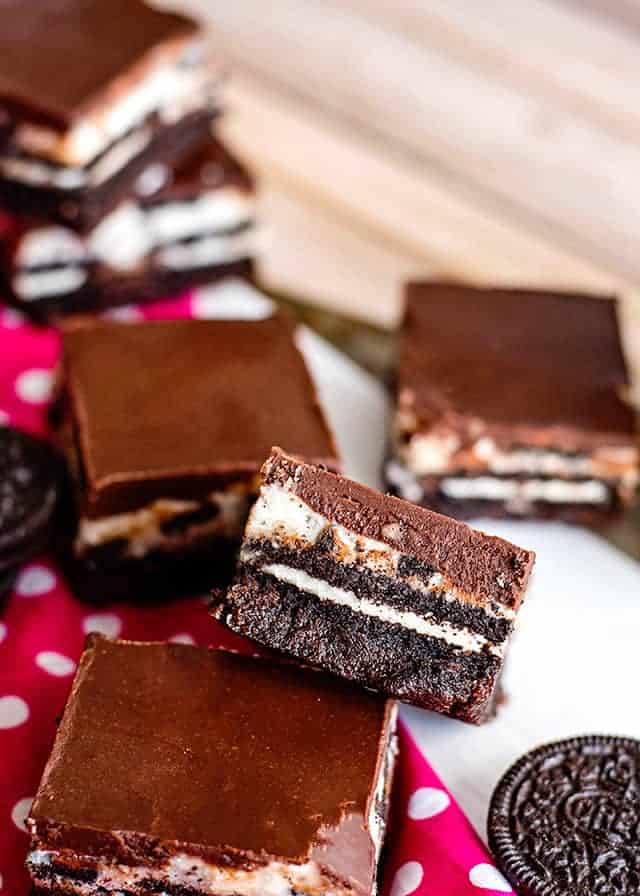 cookies and cream brownie propped up on another brownie with pink fabric under it