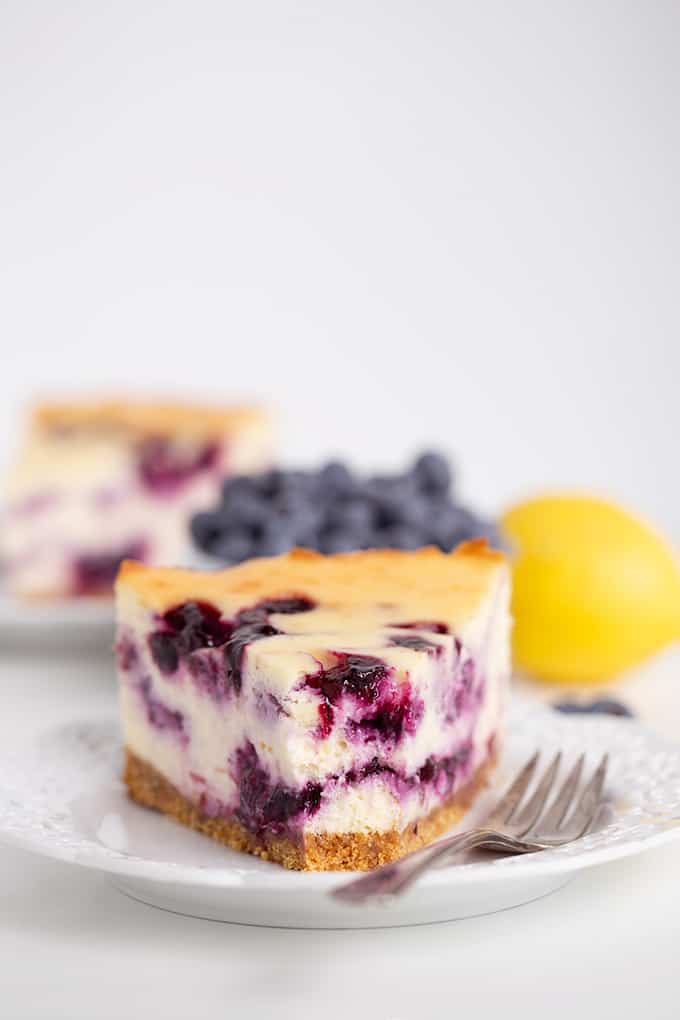 up close image of the cheesecake with a bite taken out of it with a fork on the plate