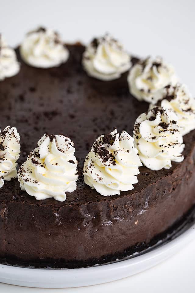 whole oreo cheesecake on a white plate with a white background