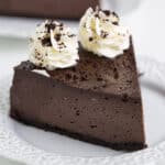 A decadent slice of Oreo cheesecake on a plate.