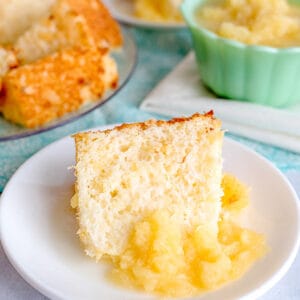 slice of pineapple angel food cake on a white plate with a pineapple sauce