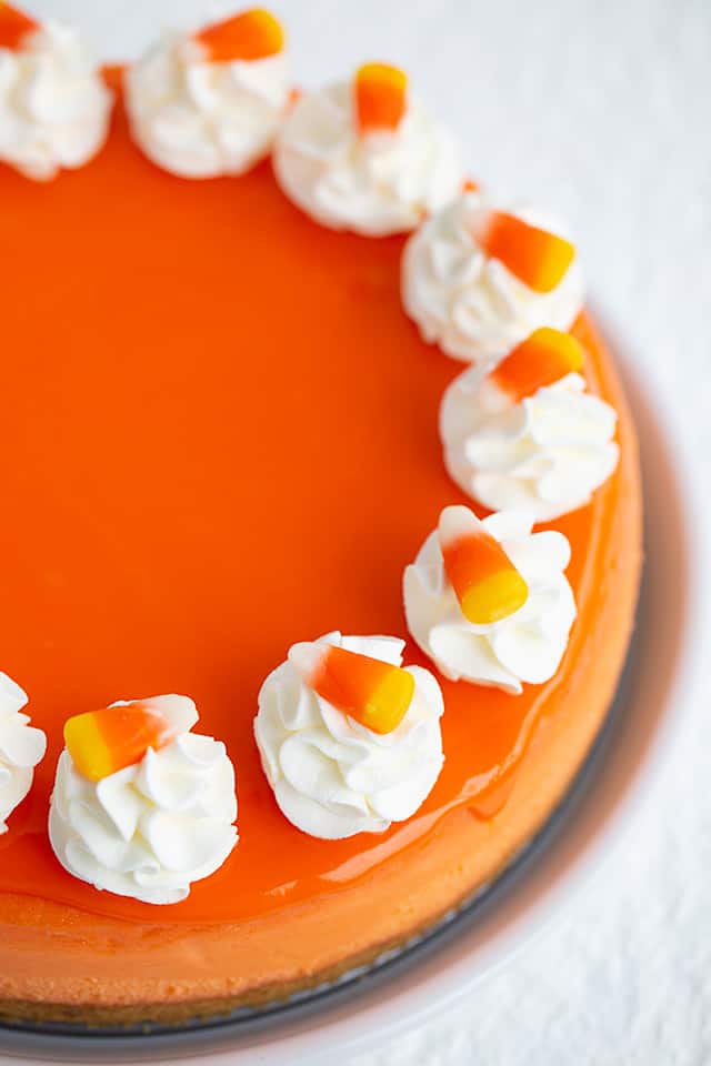 overhead photo of whole cheesecake focusing on whipped cream and candy corn pieces