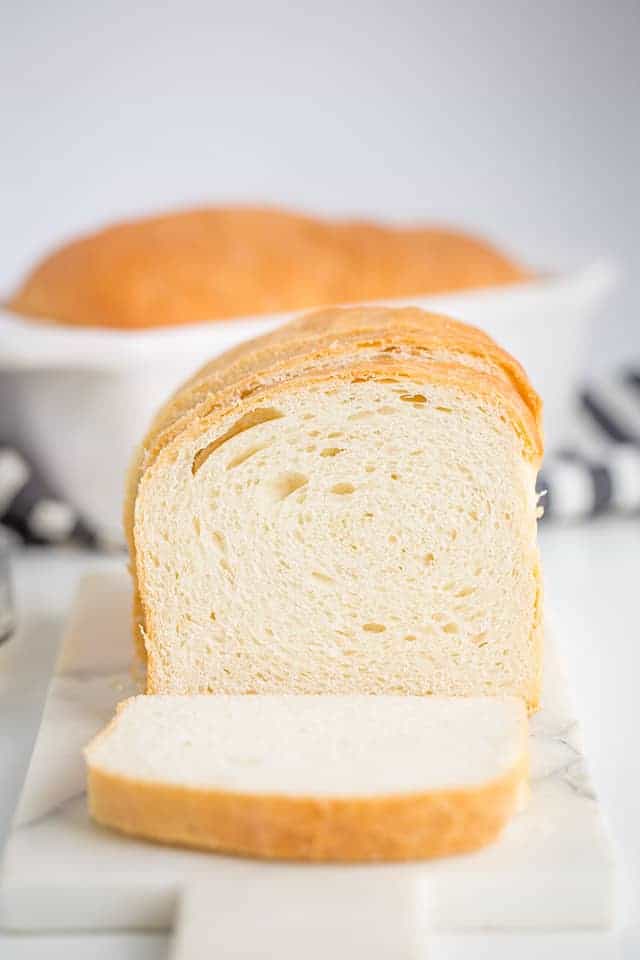 sliced loaf of homemade bread on a marble cutting board