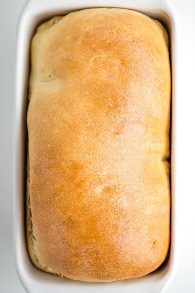 overhead photo of homemade bread in a white loaf pan