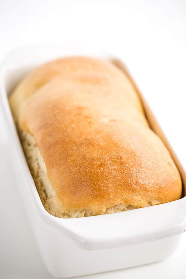 loaf of baked homemade bread in a white loaf pan