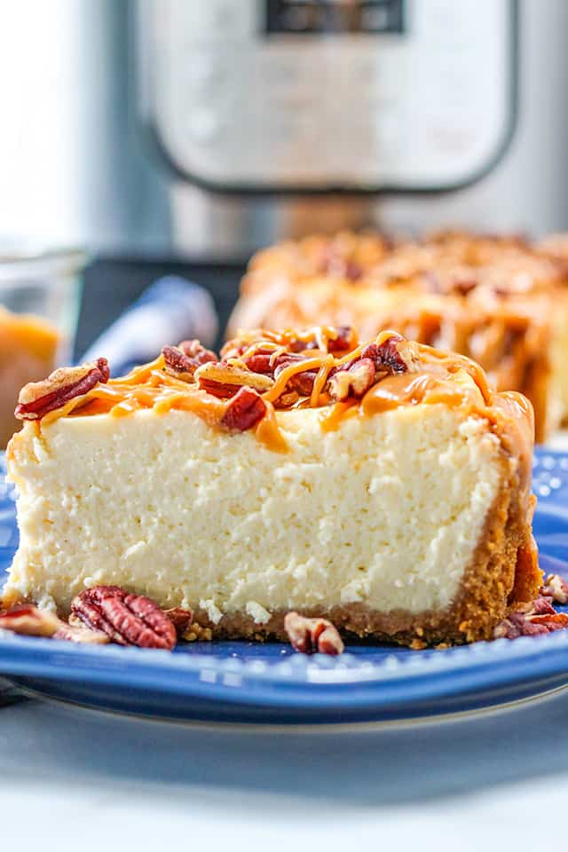 close up of slice of cheesecake on a blue plate with IP behind it