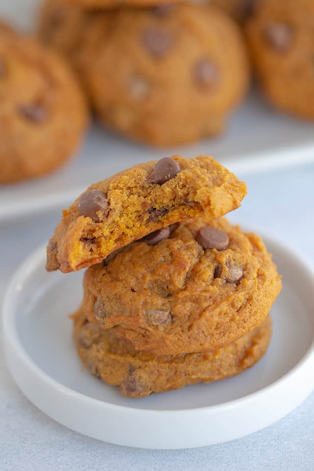 stack of pumpkin cookies with a bite taken out of the top one