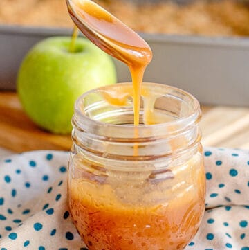 spoon full of caramel sauce dripping into a jar