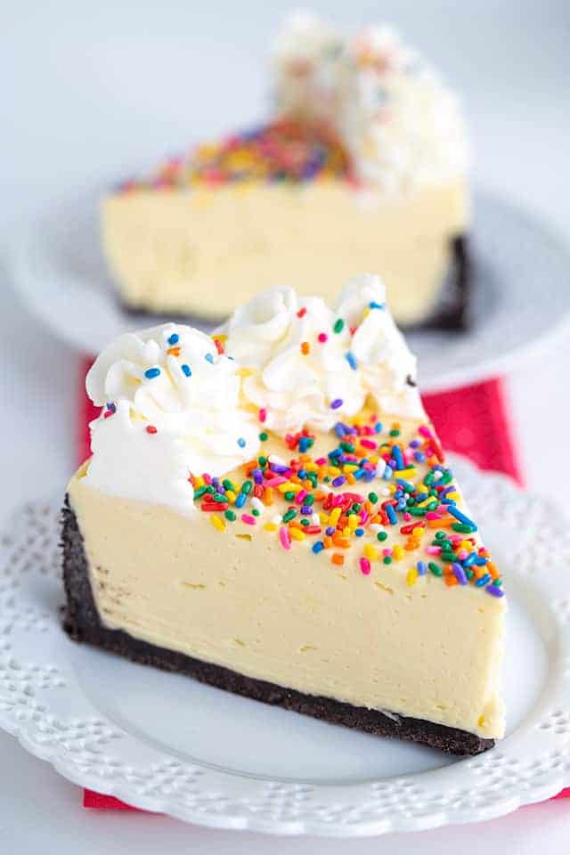 no bake cheesecake on a white lace dessert plate with a second slice behind it