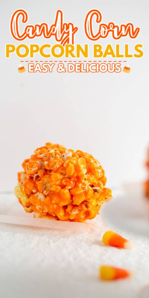 zoomed in photo of a popcorn ball on parchment paper with candy corn in front of it and text at the top