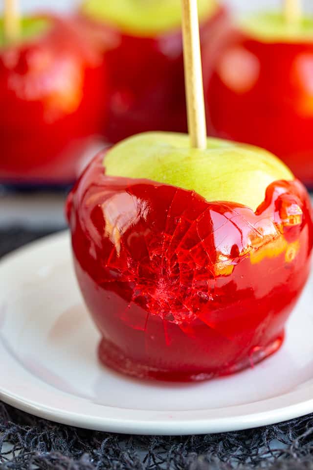 smashed candy apple on a larger white dessert plate