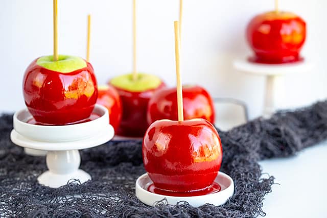 candy apples placed on cupcake stands with black string around them