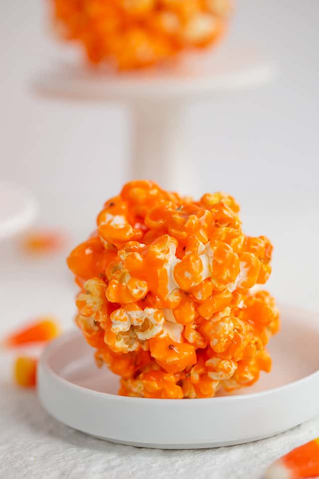 orange popcorn ball on a small white plate