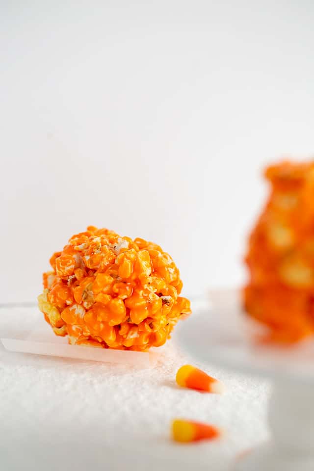 candy corn popcorn ball with candy corn around it on a white surface