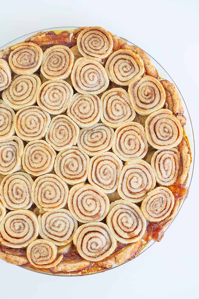 baked pie showing the golden brown cinnamon roll crust on a white background