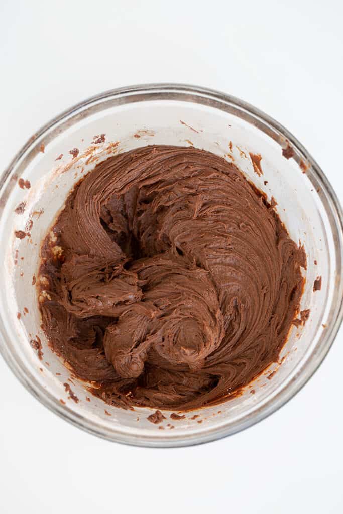 chocolate cream cheese frosting in a glass bowl with a white background