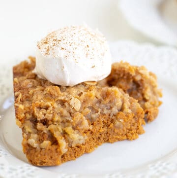 close up of pumpkin crisp with whipped cream and a dusting of cinnamon on top