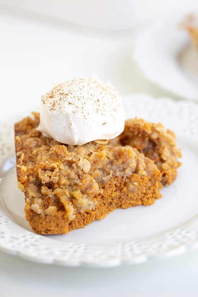 close up of pumpkin crisp with whipped cream and a dusting of cinnamon on top