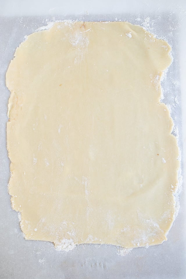 pie crust rolled out into a rectangle on parchment paper