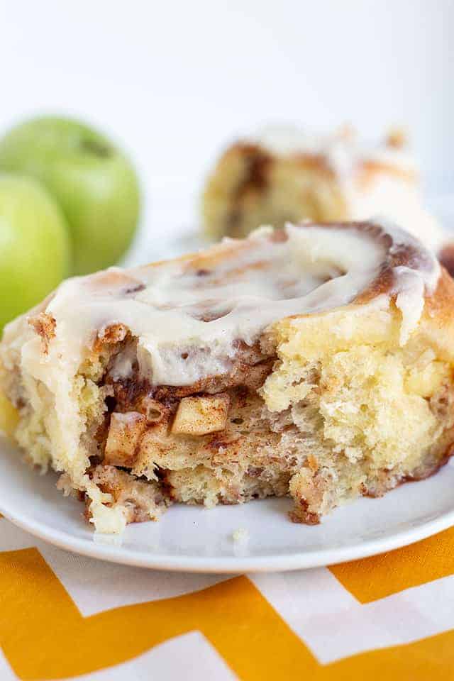 up close photo of the roll with apples poking out the side of the roll and apples behind it