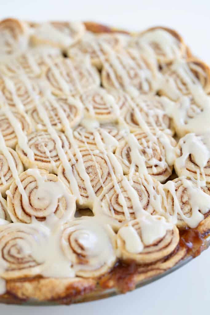 close up of the cinnamon roll apple pie with a glaze on top
