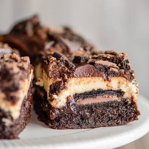 closeup of a brownie bar on a white cake plate