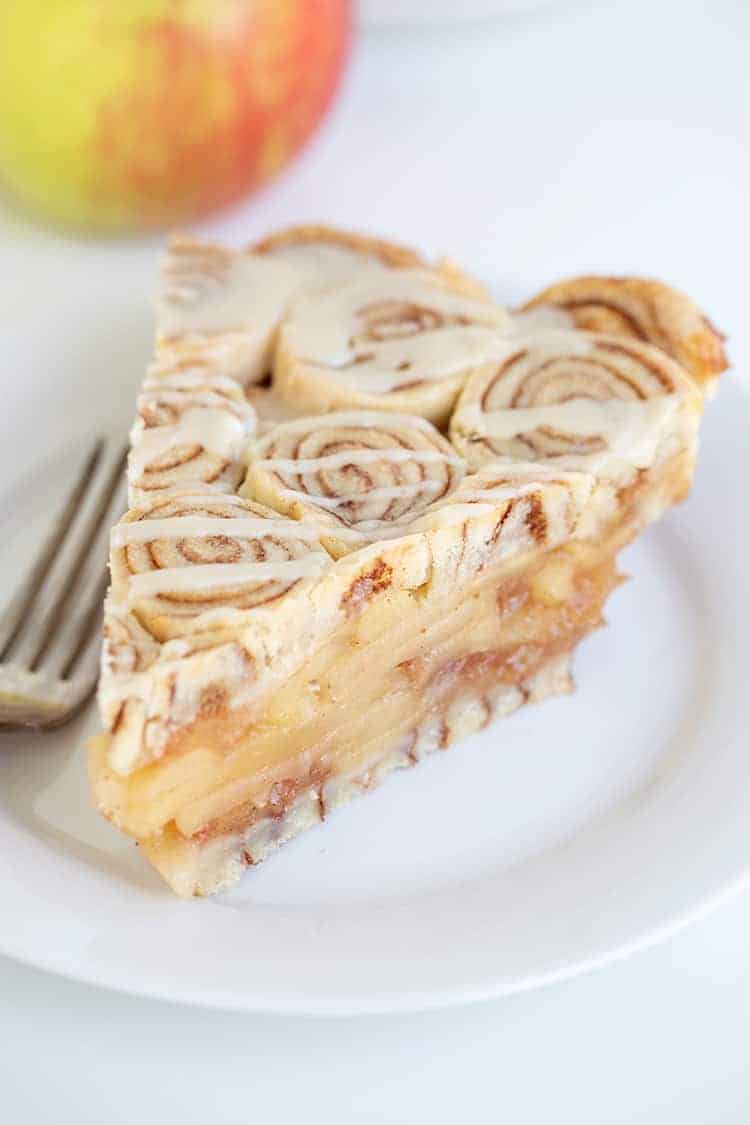 slice of cinnamon roll apple pie on a white plate with a fork