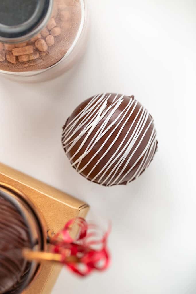 overhead photo of chocolate bomb with a jar of hot cocoa mix in a mug