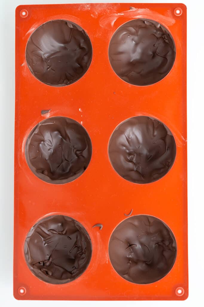 an orange silcone mold filled with chocolate