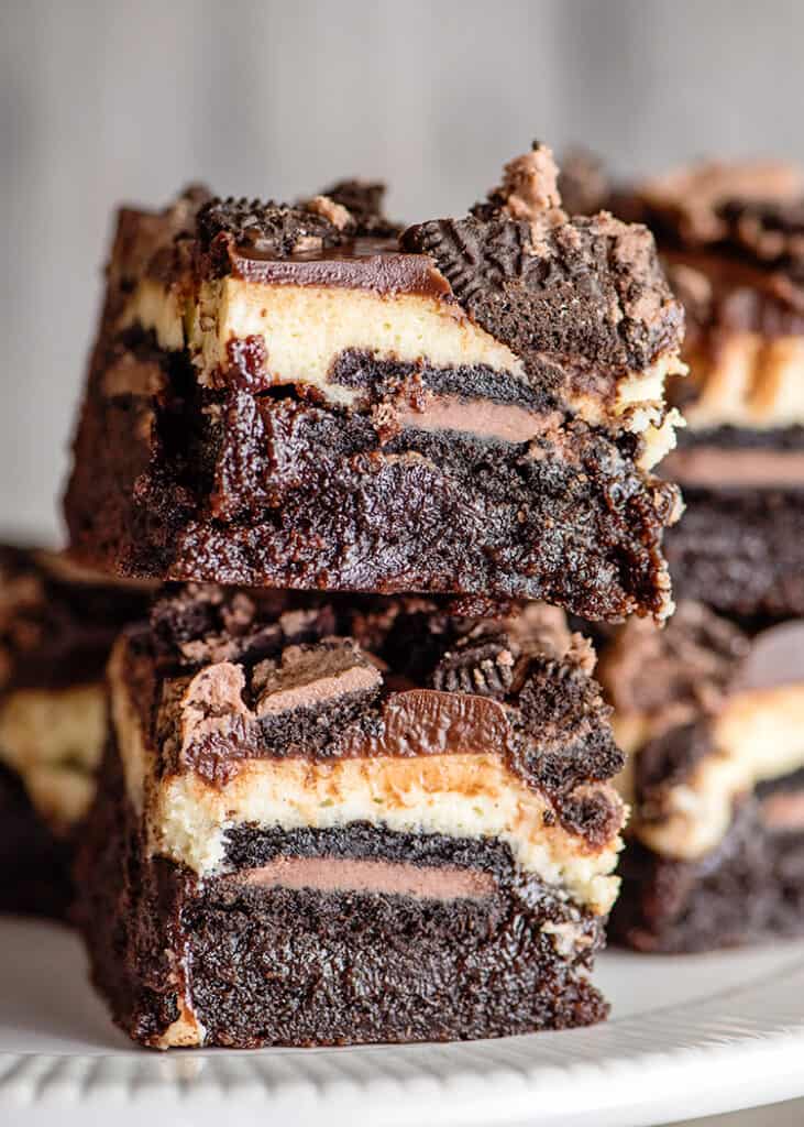 stack of brownie bars on a white surface