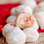 peppermint balls on a burlap fabric with one cookie broke in half showing the middle