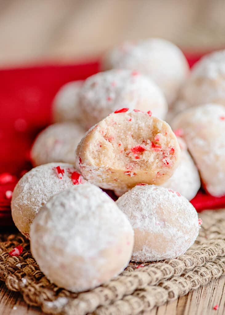 peppermint balls on a burlap fabric with one cookie broke in half showing the middle