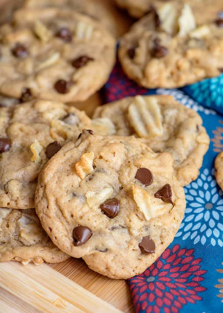 cookie laid on top of other cookies on a cutting board with a blue and pink flowered fabric