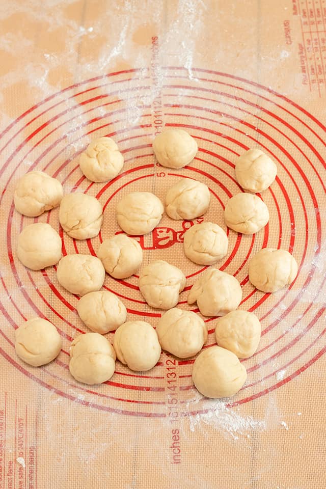 small dough balls on a mat that's dusted with flour