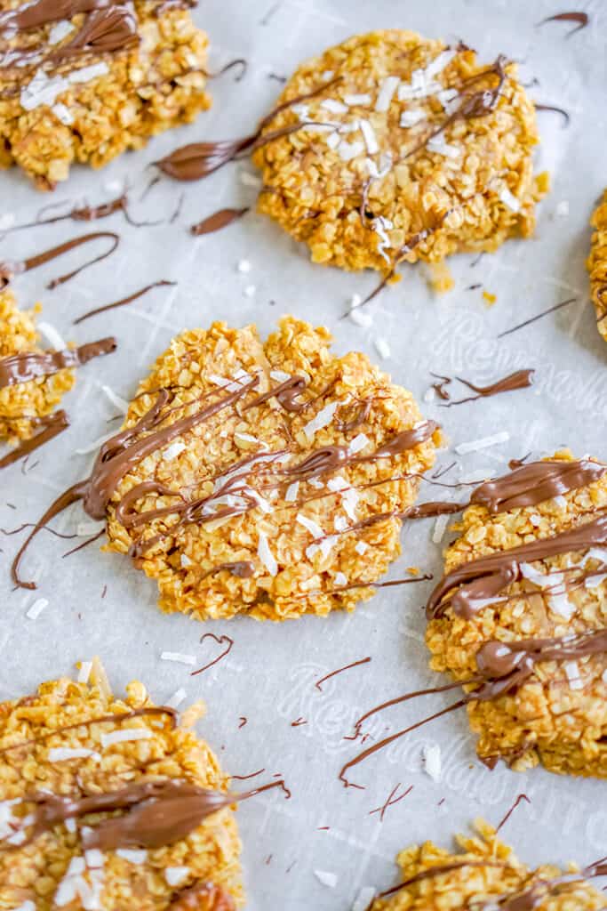 overhead photo of cookies drizzled with chocolate on a piece of parchment paper