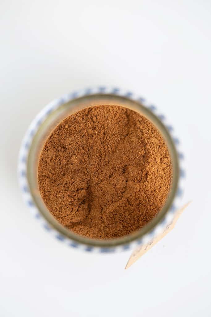 looking straight down into a glass jar to see the spices with a white surface