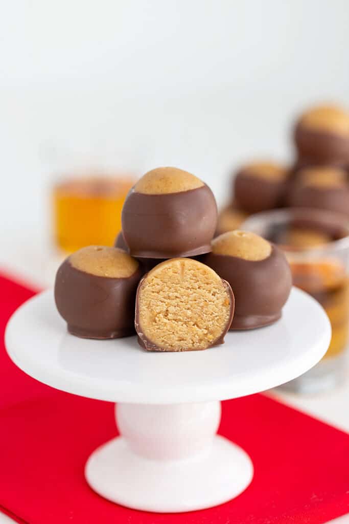 whiskey balls on a cupcake stand with one of the balls cut in half