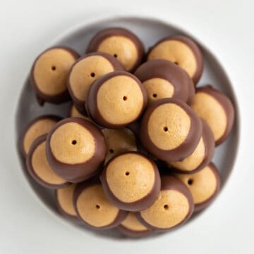 overhead photo of stacked buckeyes on a white plate on a white surface