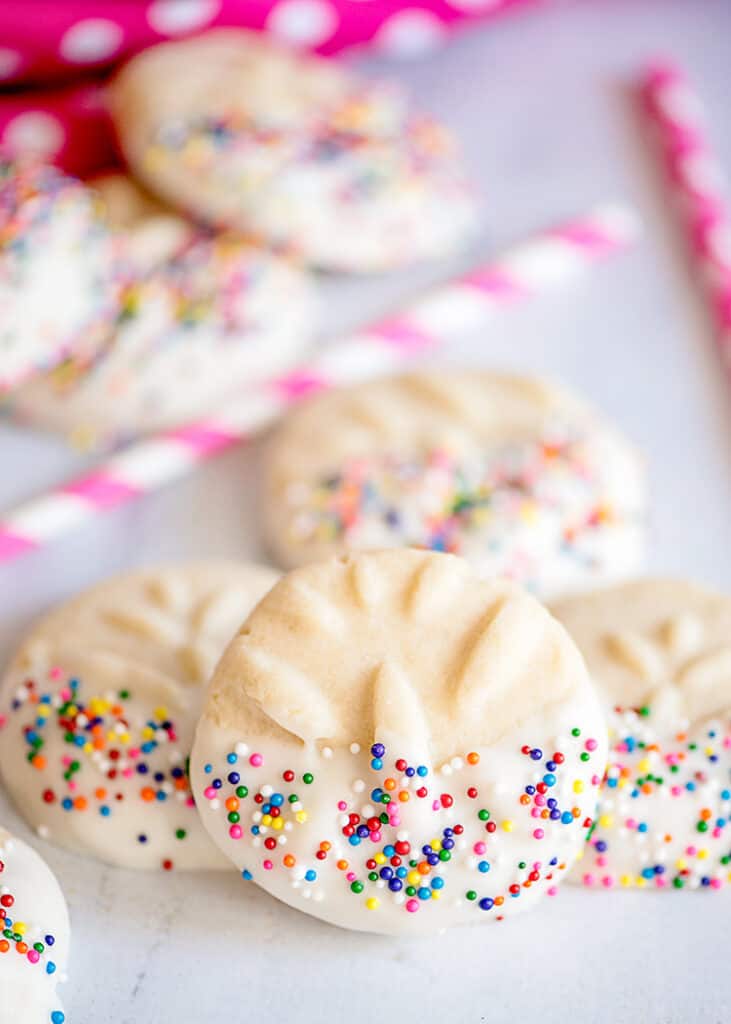 butter cookie propped against other cookies on a marble surface