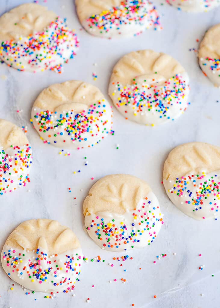 cookies on wax paper with almond bark and sprinkles