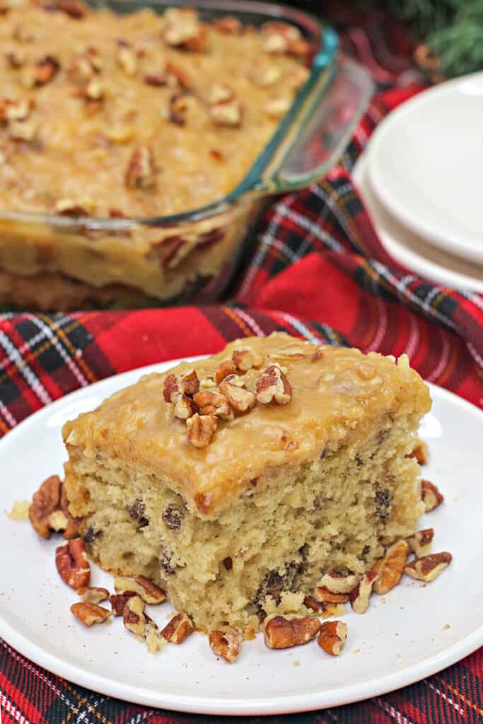 cake on a white plate with pecans around it