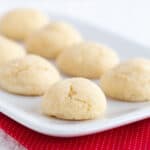 cookies on a white platter with a red polka dotted fabric under it