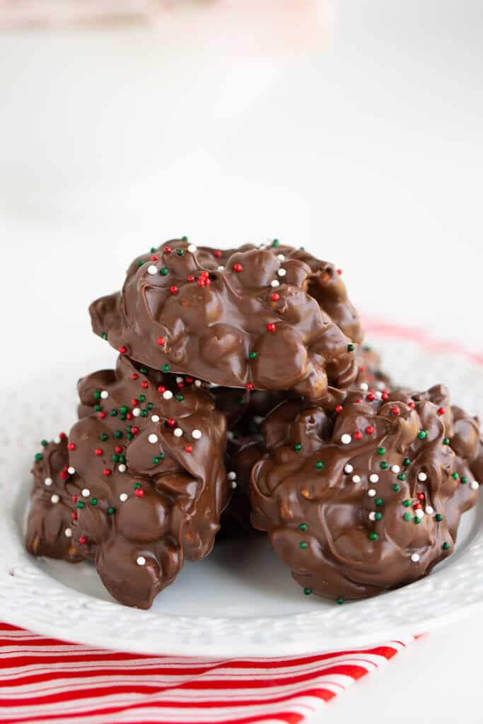 crockpot candy on a white plate with a striped fabric under it