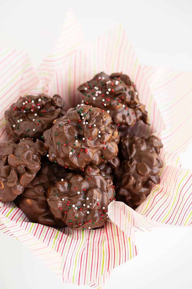 overhead photo of crockpot candy in a parchment lined white bowl