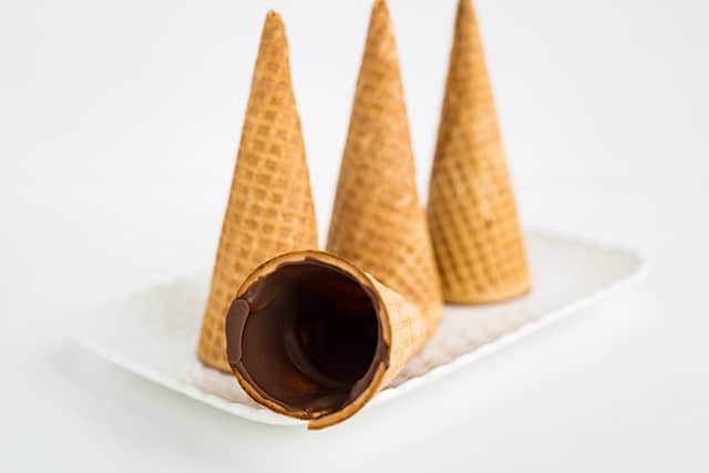 chocolate coated cones on a white plate