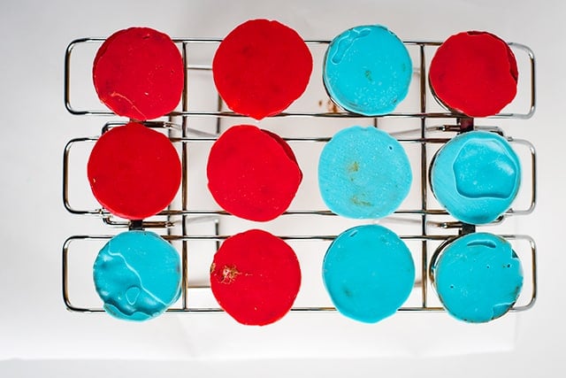 blue and red bottoms of cones on a ice cream cone baking rack on a white surface