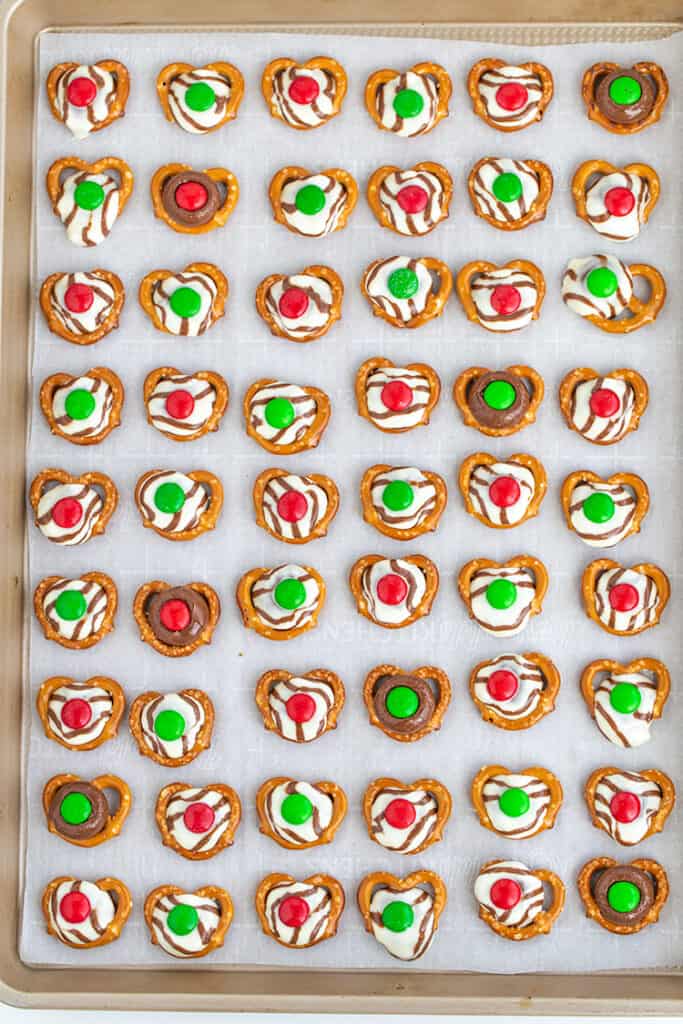 overhead photo of Christmas pretzel hugs on a parchment lined baking sheet