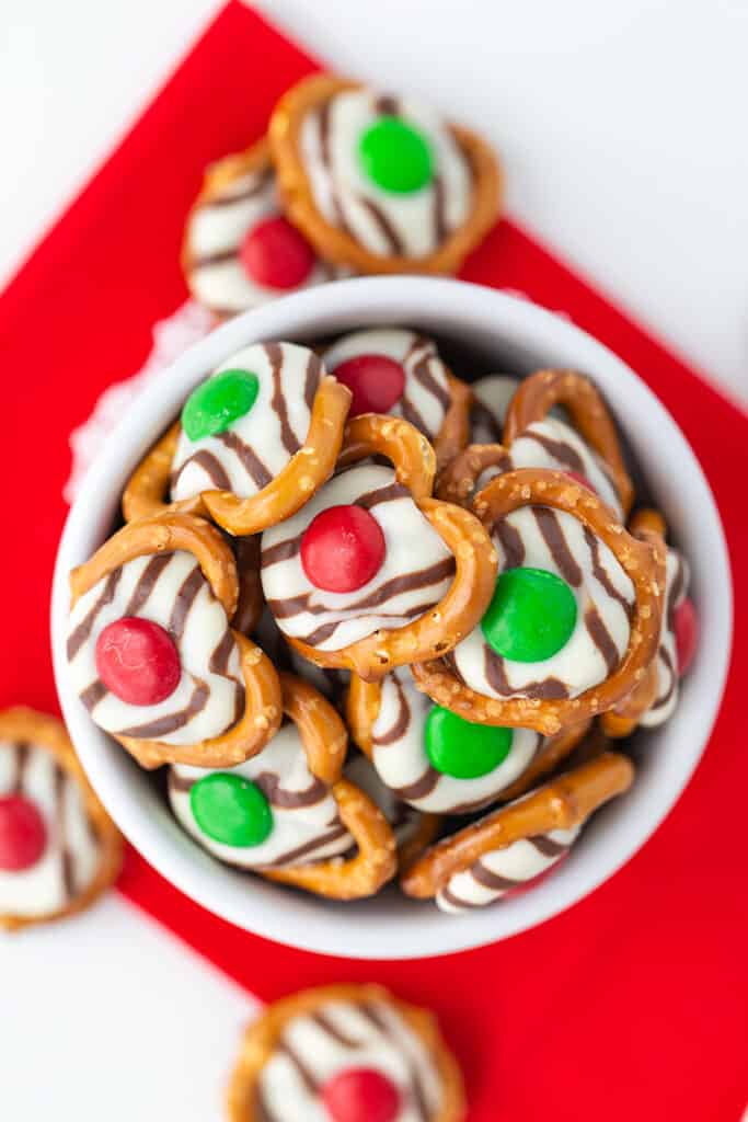 overhead photo of treats in a white bowl on top of a red fabric