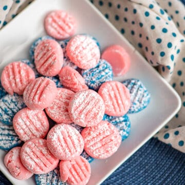 square plate full of cream cheese mints on a blue surface with a white and blue fabric